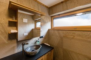 Großzügige Bäder mit Naturstein und Holz